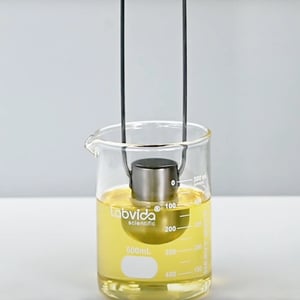 Zahn cup being dipped in a beaker full of oil